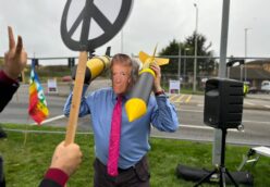 Protester at RAF Laknheath wears Donald Trump mask and holds two cardboard nuclear missiles