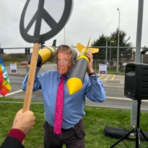 Protester at RAF Laknheath wears Donald Trump mask and holds two cardboard nuclear missiles