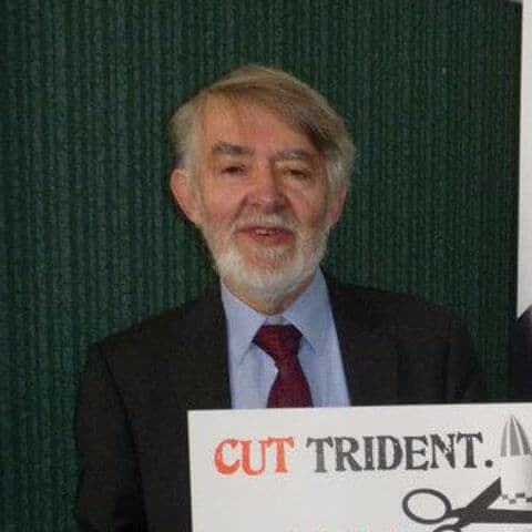 Paul Flynn holds a "Cut Trident" poster