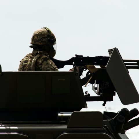 A British solider sits atop an armoured vehicle